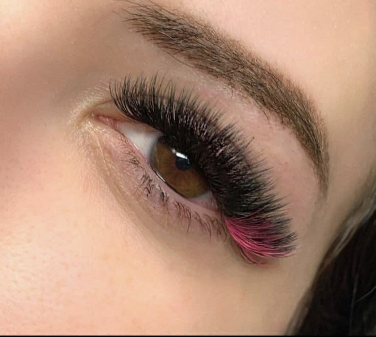 Black lash extensions with a pink accent by Medusa Beauty Studio
